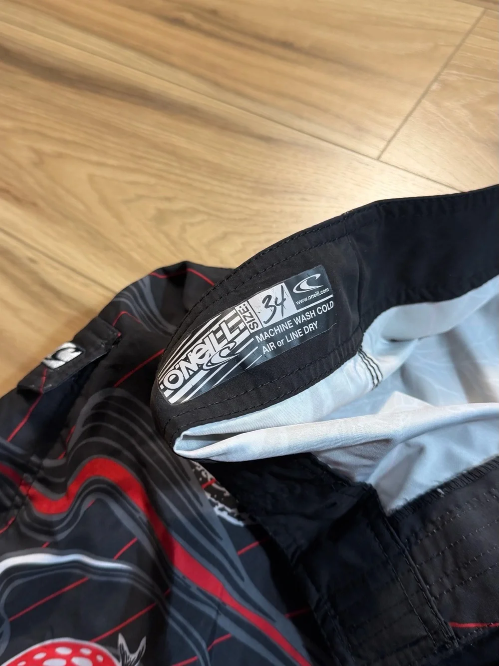 O'Neill black board shorts with white and red
